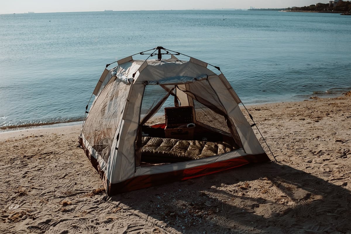 Asgard tent on a beach with the door open and bedding inside