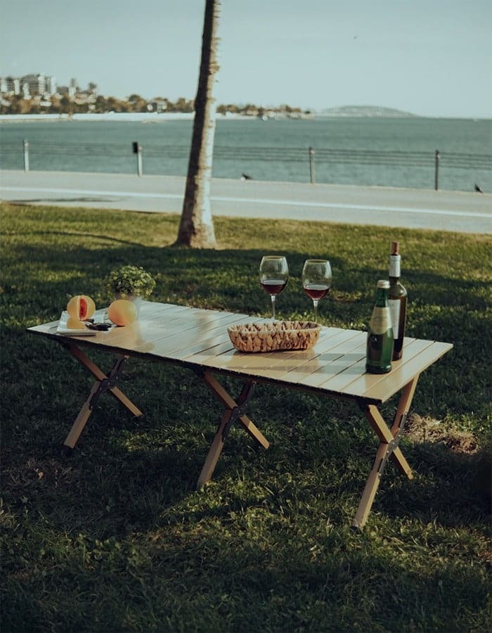 Atlas table set with wine, glasses and bread on the grass by the sea