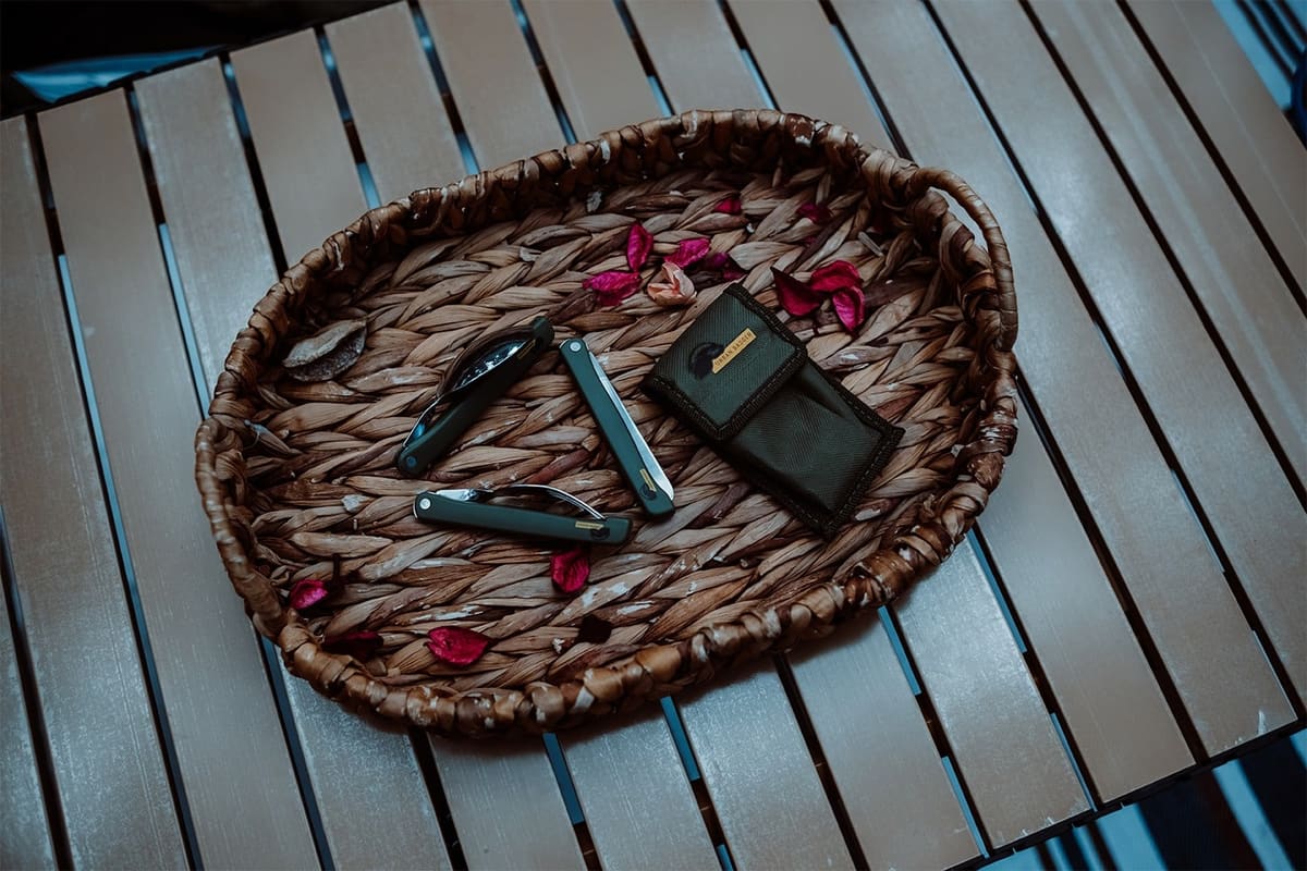 Folding cutlery in a woven tray on a slatted table, seen from above