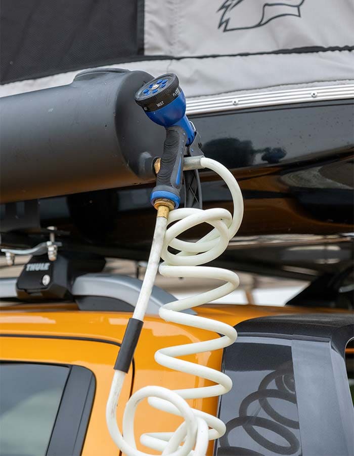Tap, spray head and coiled hose of the solar shower, close-up