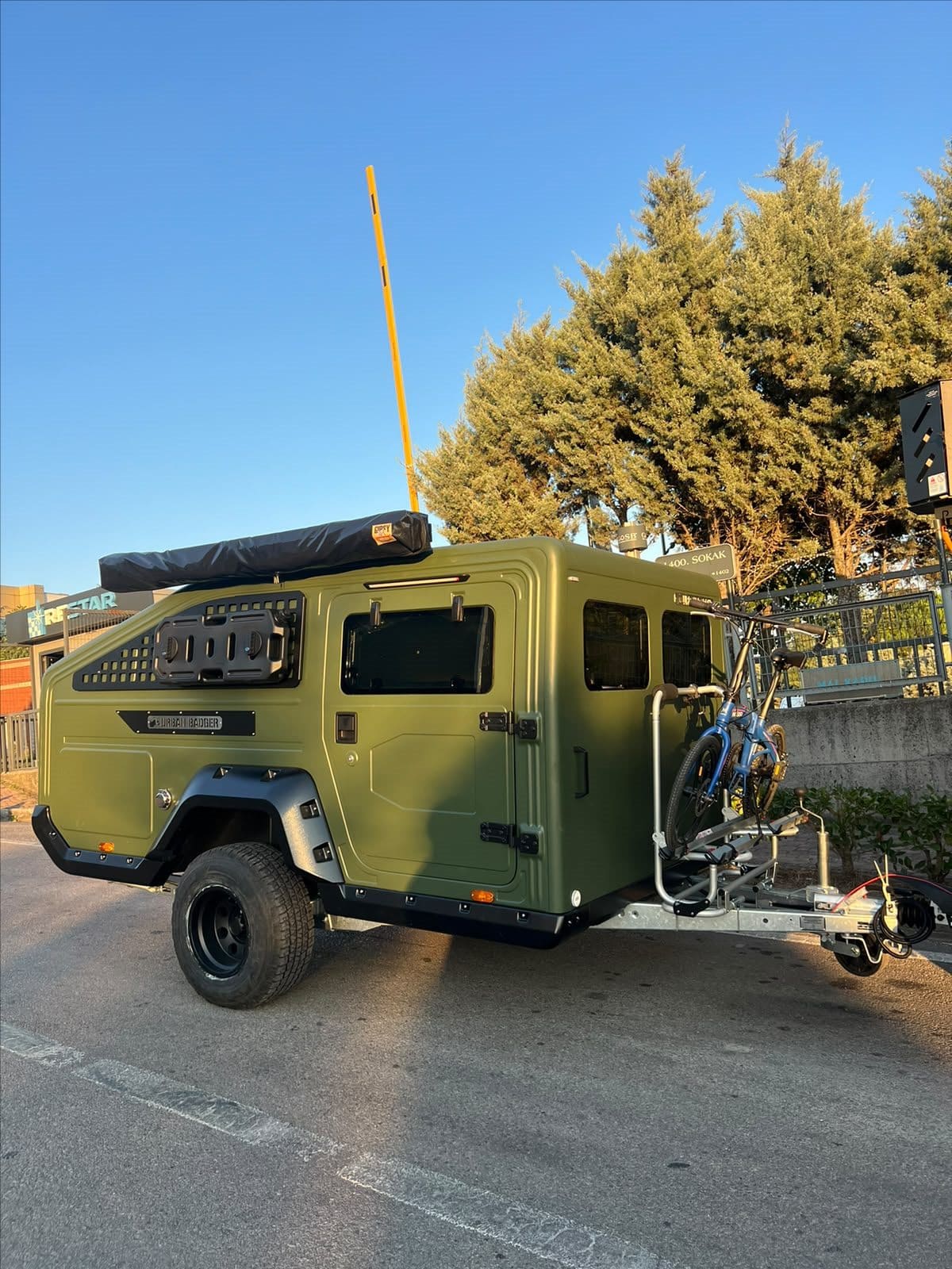 Urban Badger Towable Caravan, front three-quarter view with two bikes on the drawbar carrier