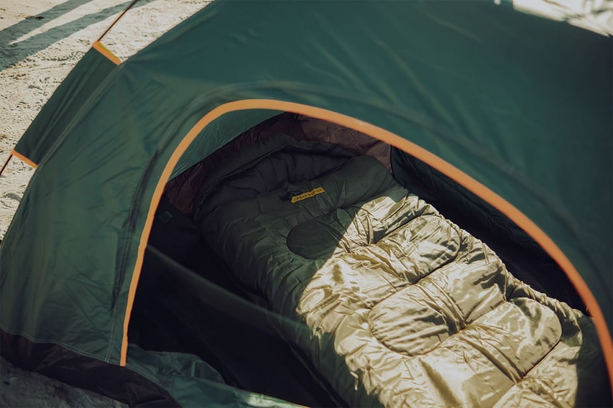 Yule sleeping bag laid out inside a Midgard tent pitched on sand